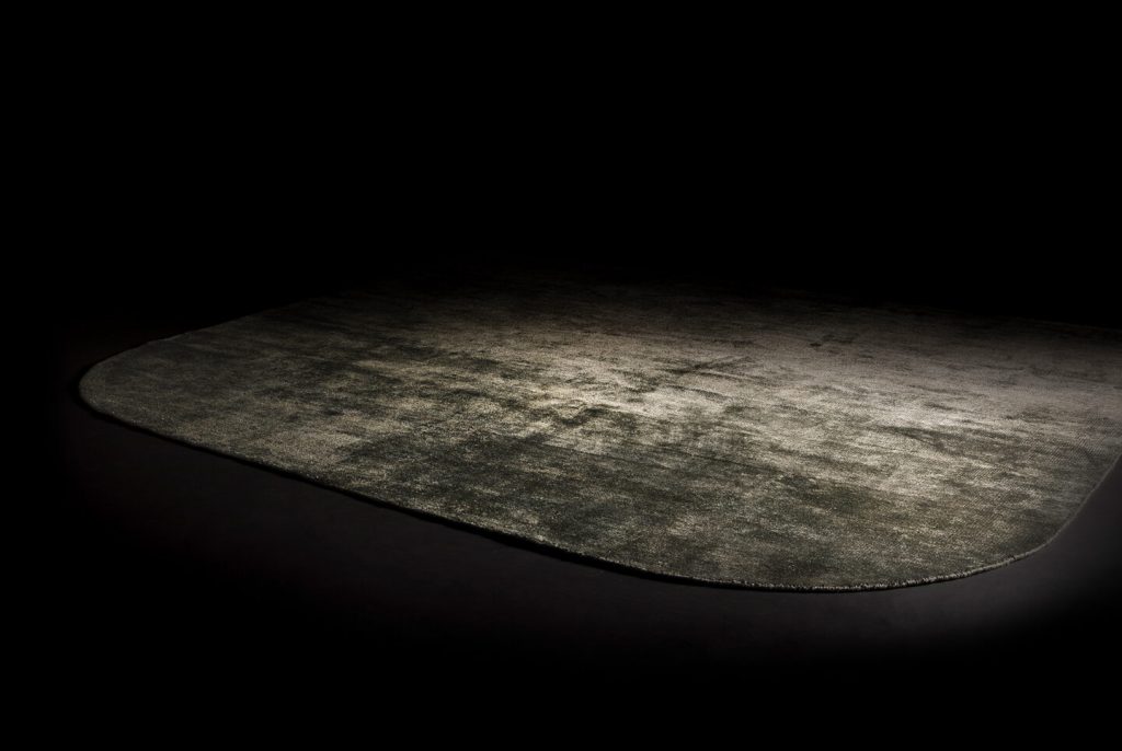 Hand-knotted rug in bamboo vegetable silk in a gray color tone on a black background