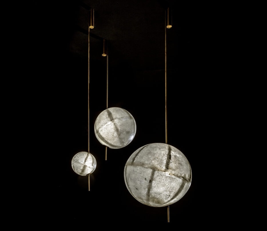 three LED lamps made of fiberglass in a tone of gray with gold on a black background