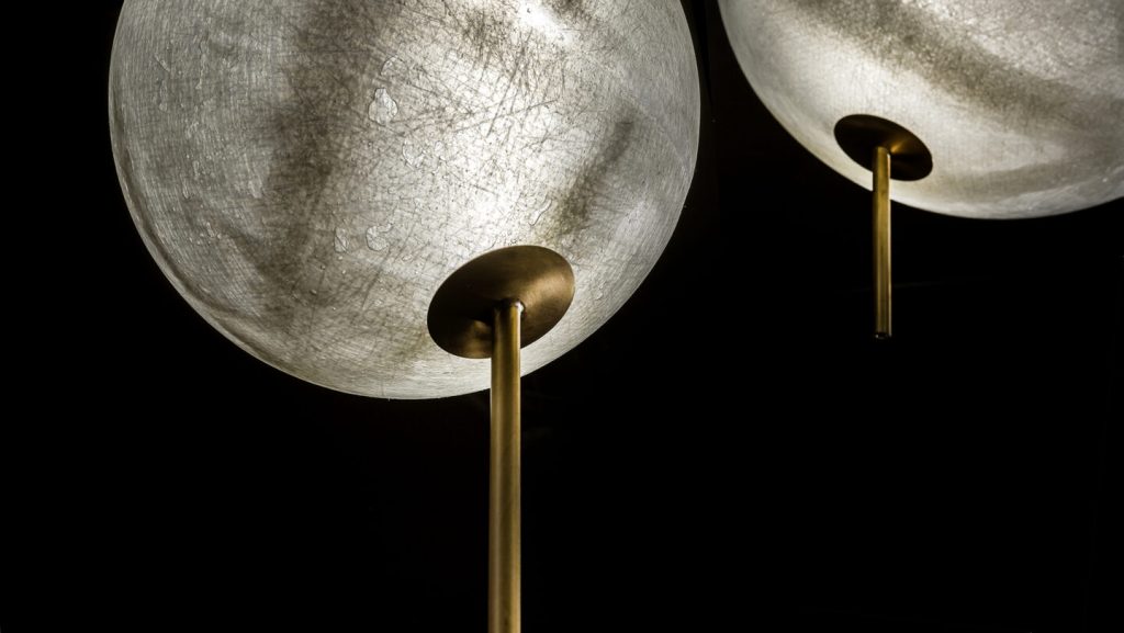 made of fiberglass in a tone of gray with gold resting on a brunidop steel base in a tone of gold color