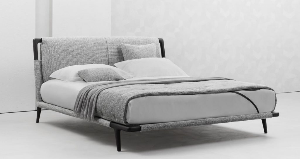 headboard and footboard made of wood and upholstered in light gray fabric on a white background