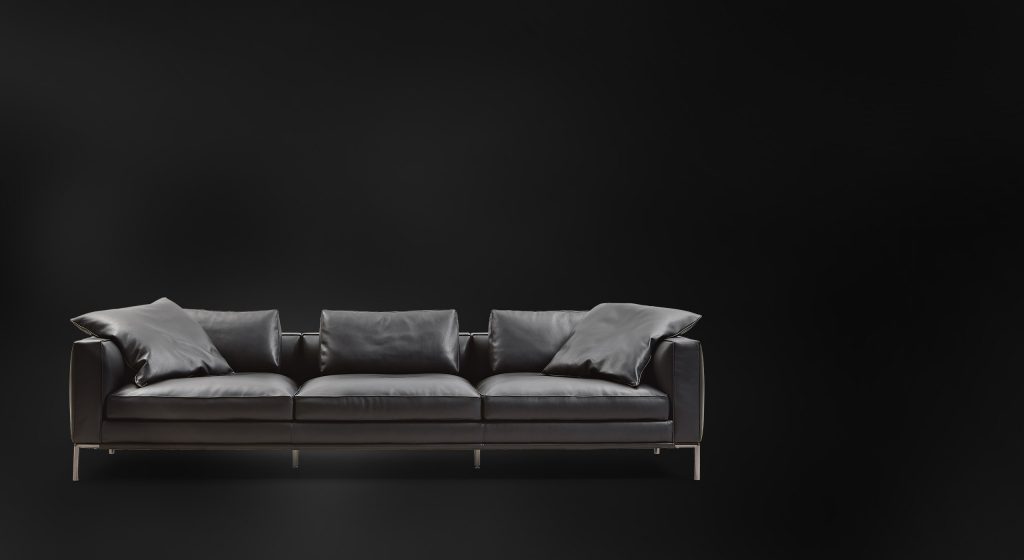 metal base and aluminum feet upholstered in black leather filled with goose down on a black background