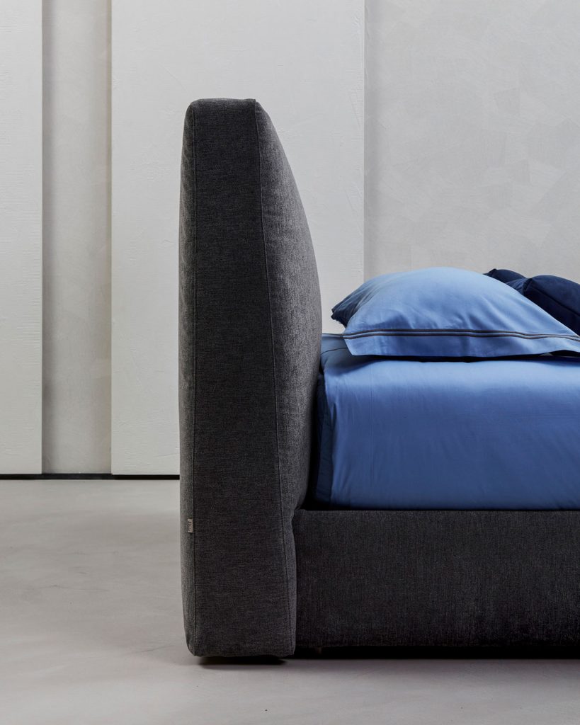 Bed headboard made of wood upholstered in dark gray fabric on a white background