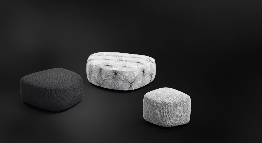 three poufs of different sizes made and covered in leather or Ecopelle fabric in shades of black, white and gray on a black background