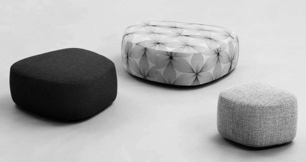 three poufs of different sizes made and covered in leather or Ecopelle fabric in shades of black, white and gray on a white background