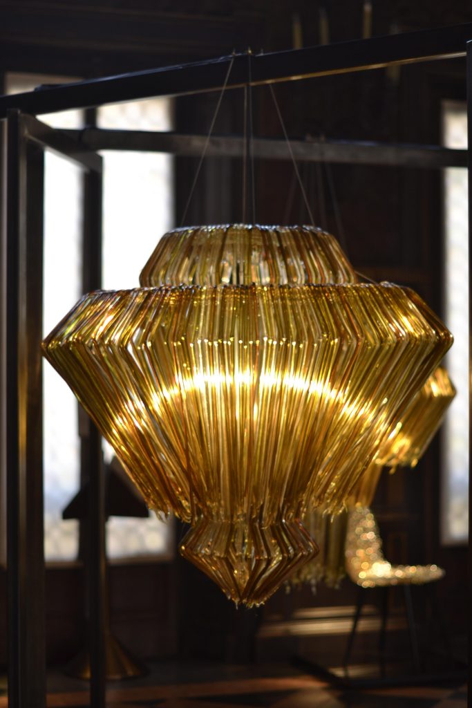 lamp made of several thin vertical strips in a golden color tone on a living room