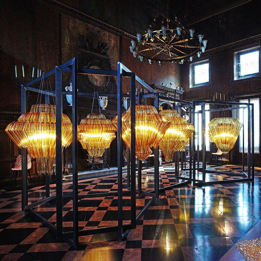 line of lamps made of several methacrylate threads in a golden tone on a white background