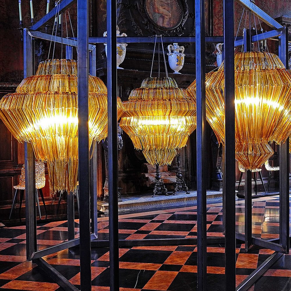 Three lamp made of several methacrylate threads in a golden tone on a white background