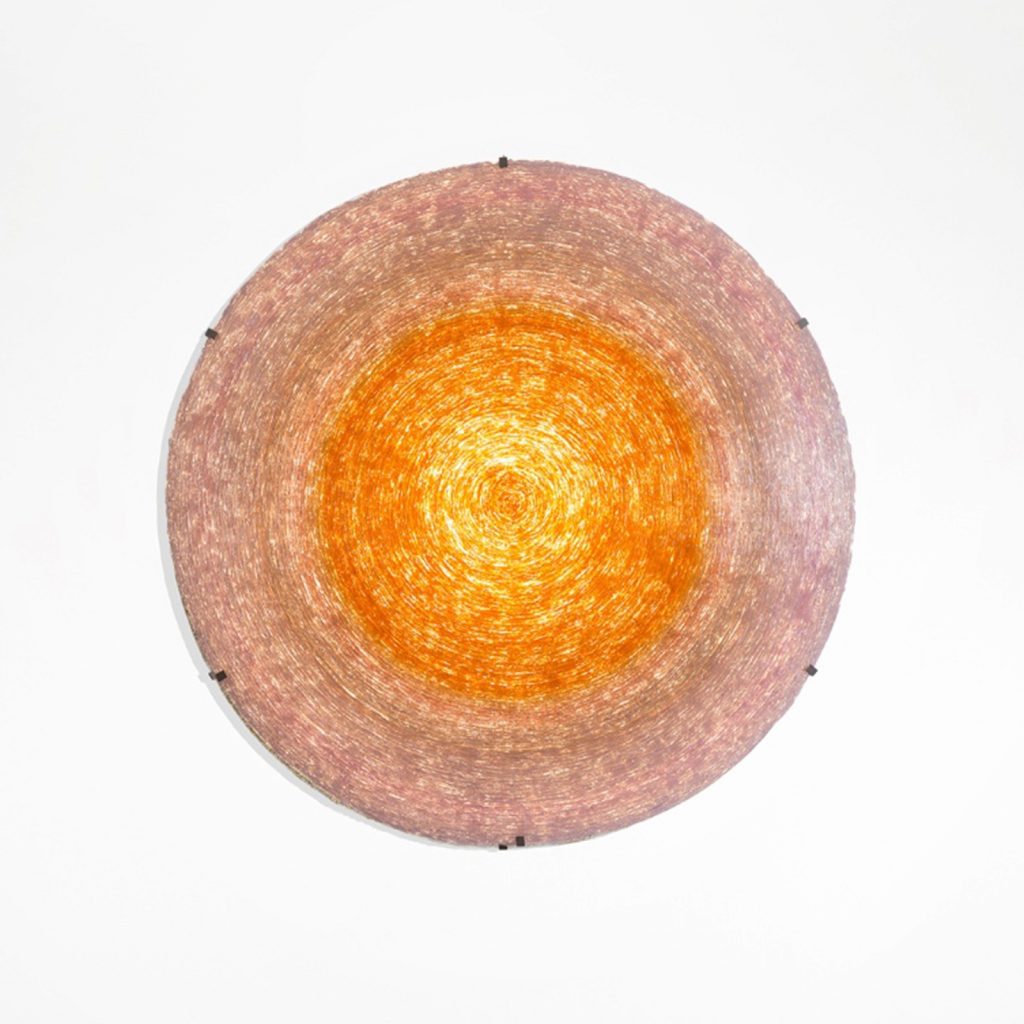 lamp made of methacrylate fused glass made in a sun-shaped design in a red-orange tone