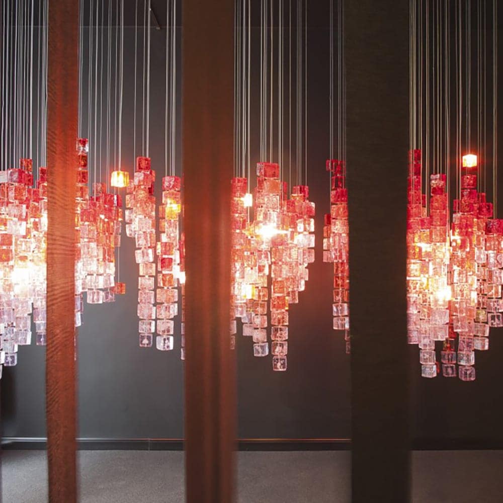 Line of chandeliers made of polycarbonate cubes in a tone of red with white on a white background