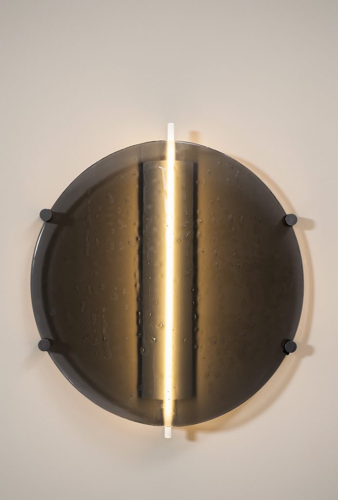 made of glass and brass dish-shaped wall lamp in a bronze color tone on a white background