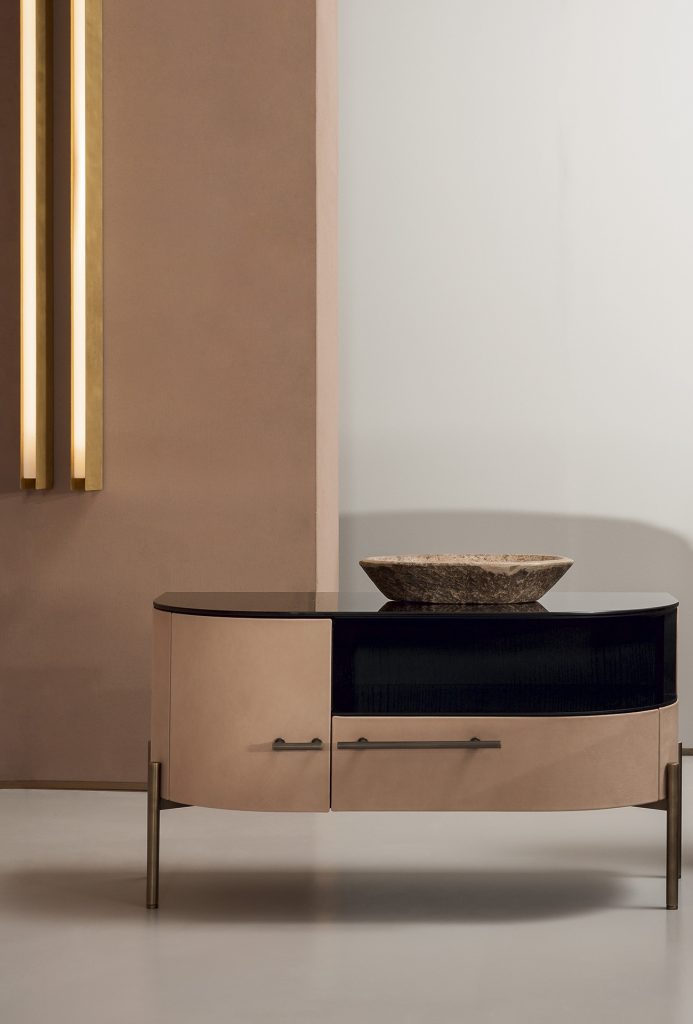 Night table made of glass, wood and aluminum in a black beige and gold tone in a living room