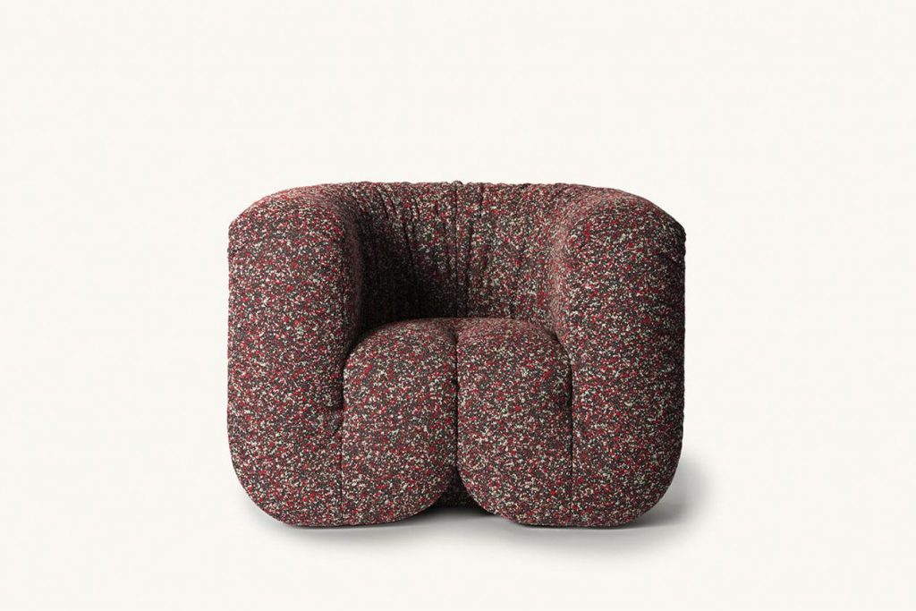 armchair made of textile fabric in a purple tone with white finishes on a white bnackground