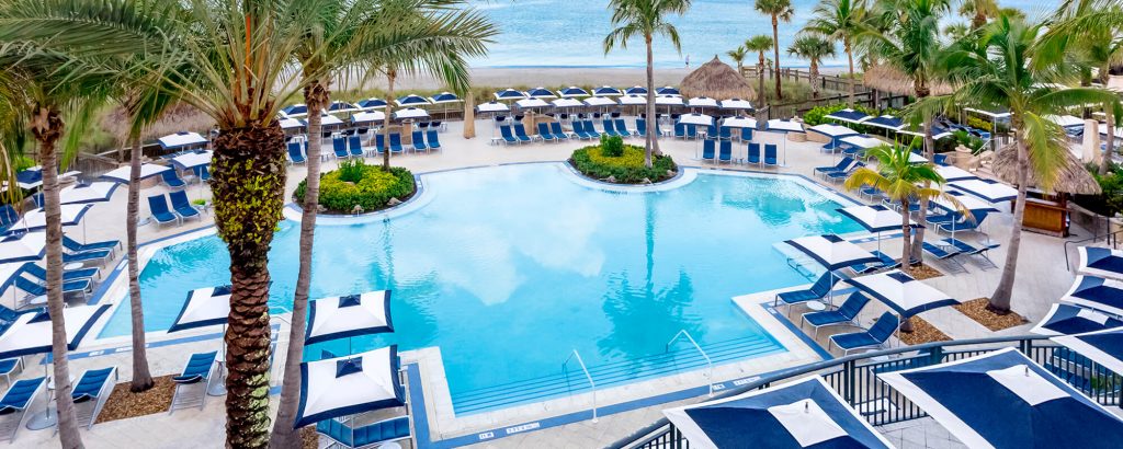 line of square umbrellas made from metla and fabric in a tone of white with blue on a pool background