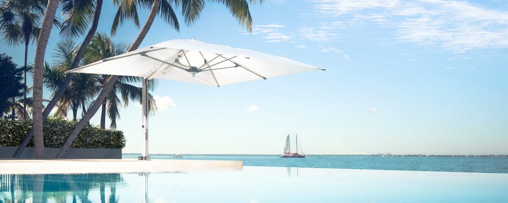 umbrella with low base made of metal and fabric in color and white tone on a beach background