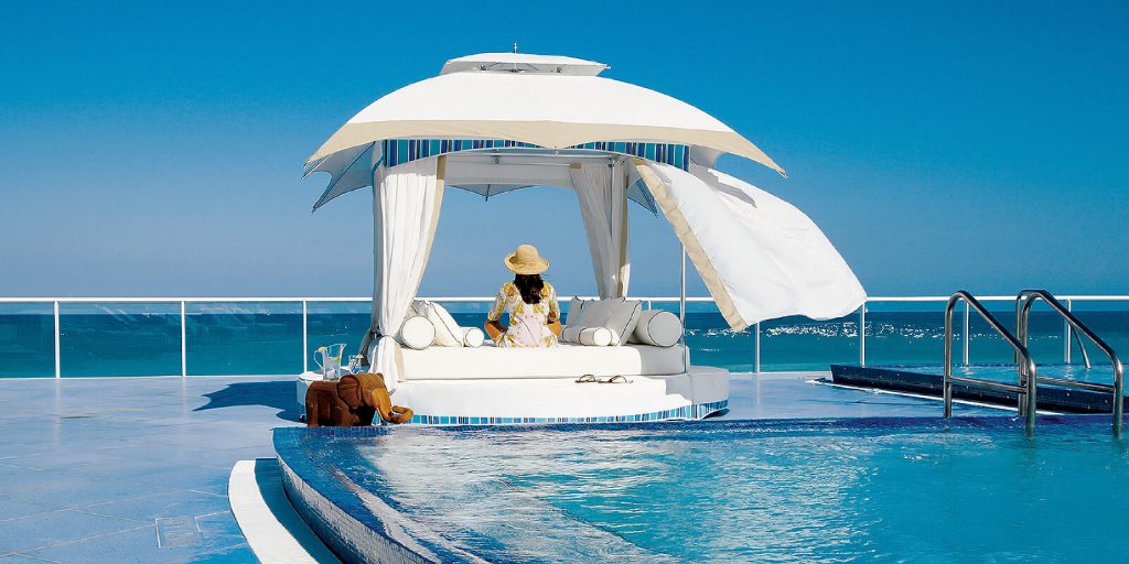 luxury oasis made on an aluminum base with cushions and curtains made on a fabric base of a white tone on a pool background