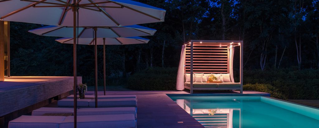 small open-air living room made of wood and metal planks in a white tone on a pool background