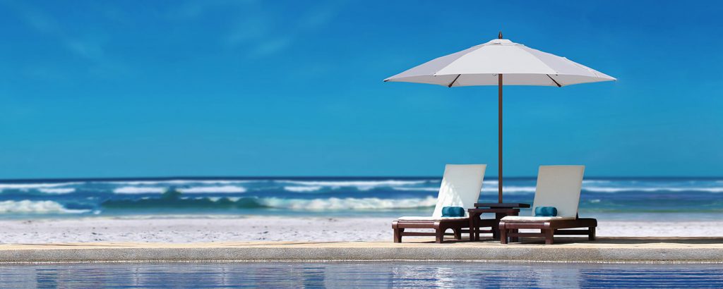 umbrella with high base made of wood and fabric in shades of brown and white on a pool background