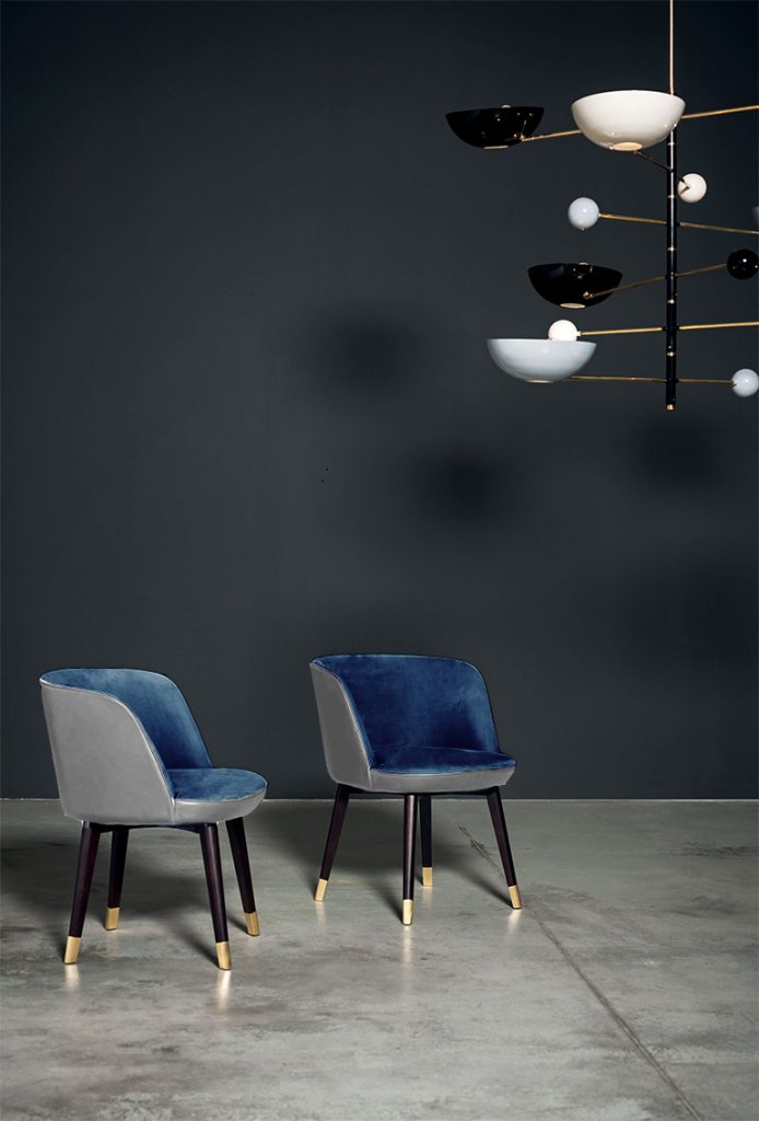 two dining chairs made from black ash legs with brass tops in a dark and light blue tone