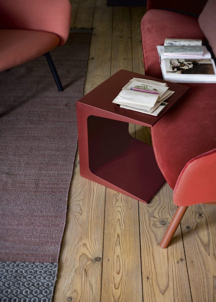 C-shaped side table made of lacquered wood base in a red tone