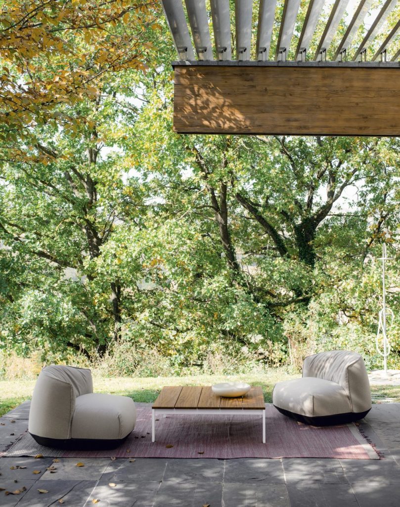 outdoor table made with steel legs and wooden plank tops in a brown and white tone