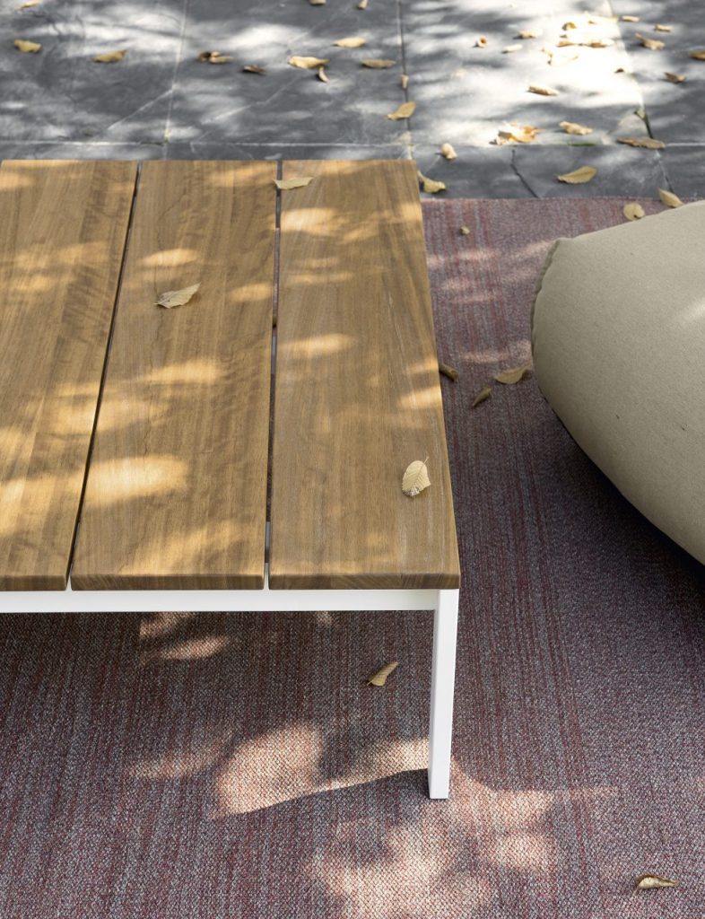 outdoor table made with steel legs and wooden plank tops in a brown and white tone