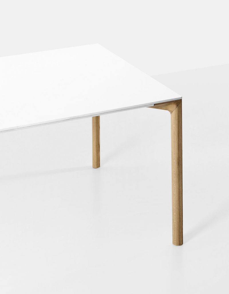 table made of polished cement base in a white tone on wooden legs on a white background