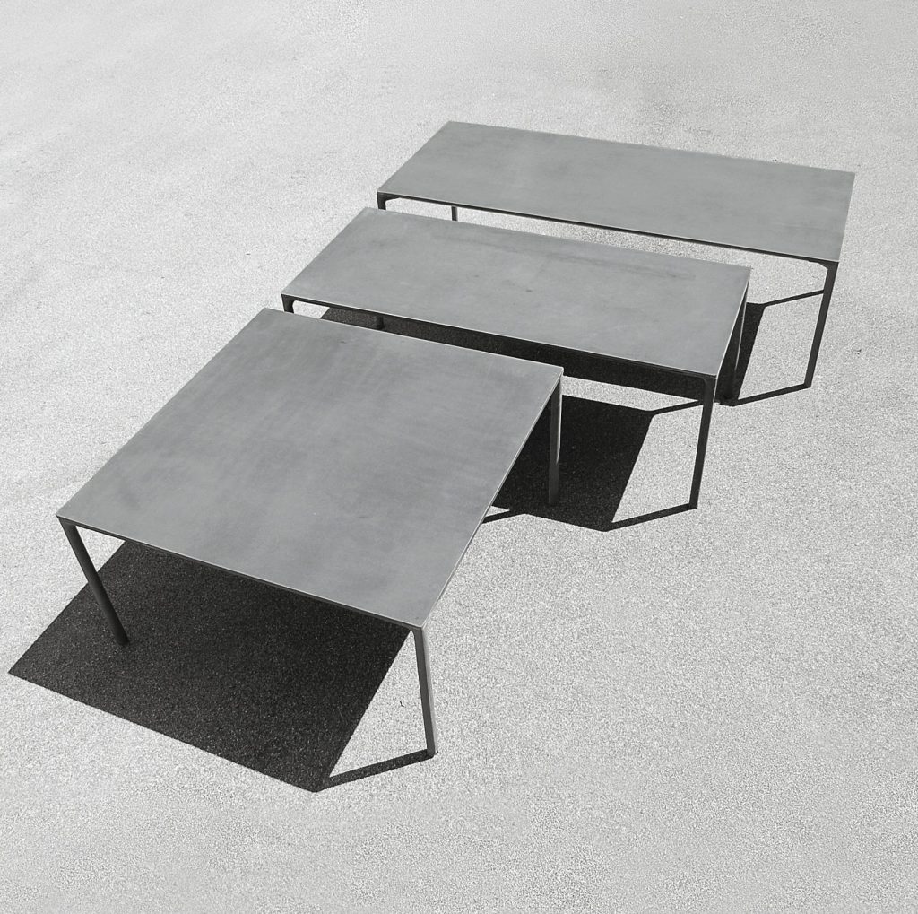 three tables made of polished gray cement on a wooden base on a gray background