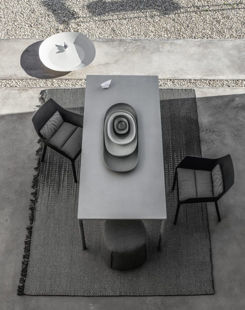 table made of polished cement in a gray tone with three chairs around it
