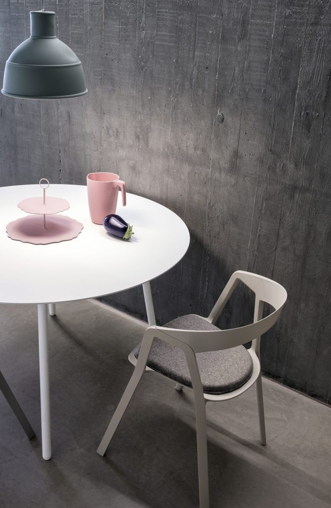 chair made of plastic in a white tone with gray fabric cushion
