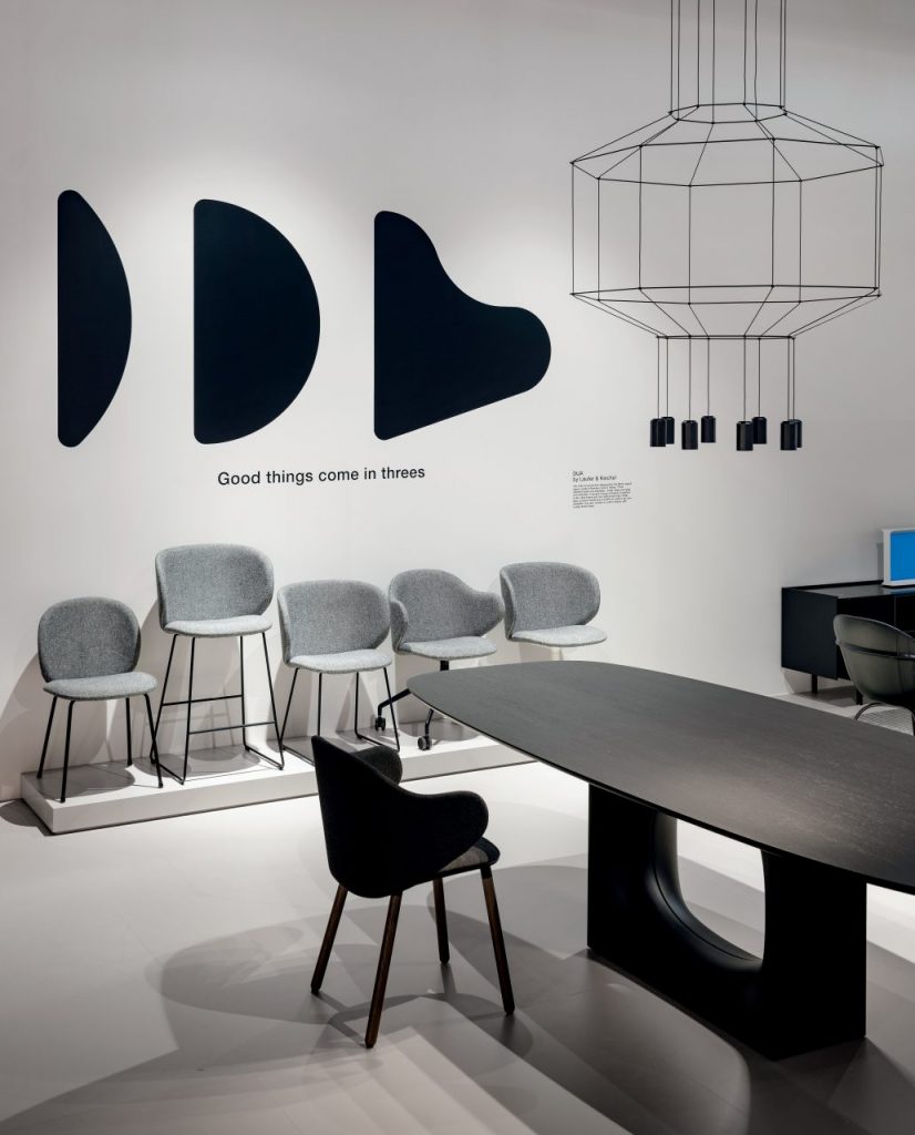 line of chairs made with aluminum or wooden legs upholstered in gray fabric