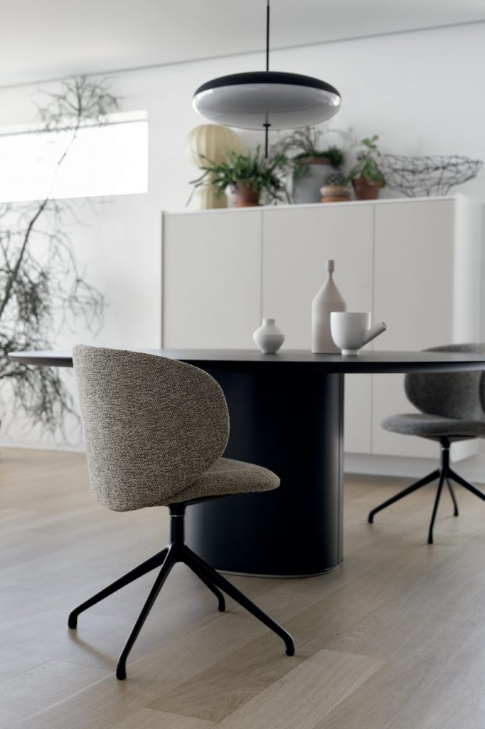 chair made from a tripod base and upholstered in light brown fabric in an office