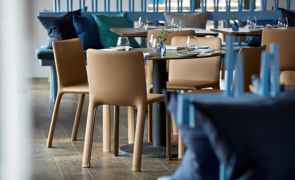 line of chairs covered in beige fabric on an aluminum base