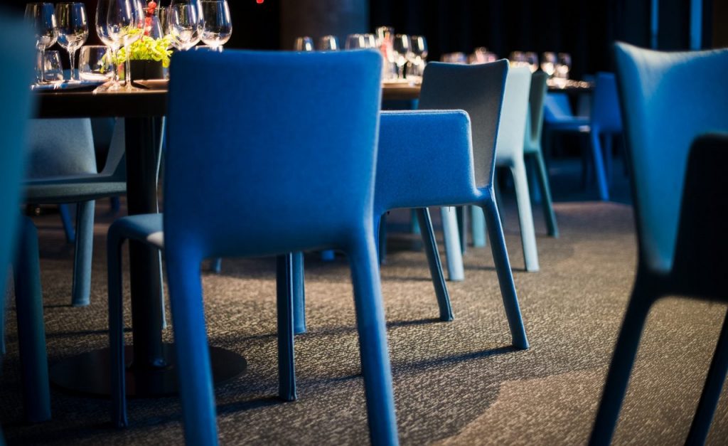 line of chairs covered in blue and light blue fabric on an aluminum base