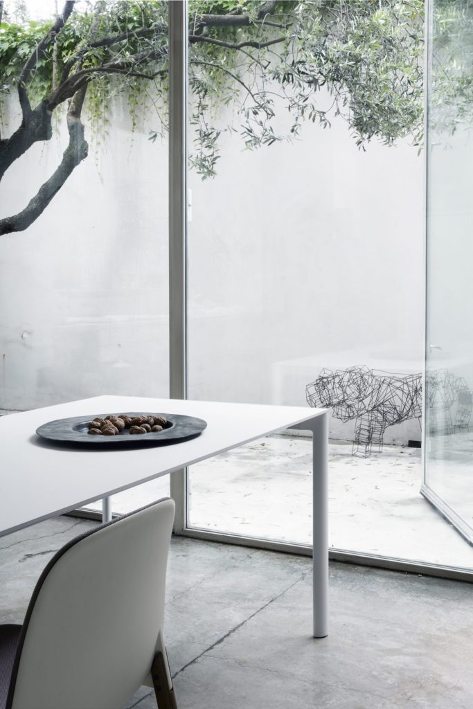 table made in a rectangular shape with an aluminum base and cirtsal in a white tone