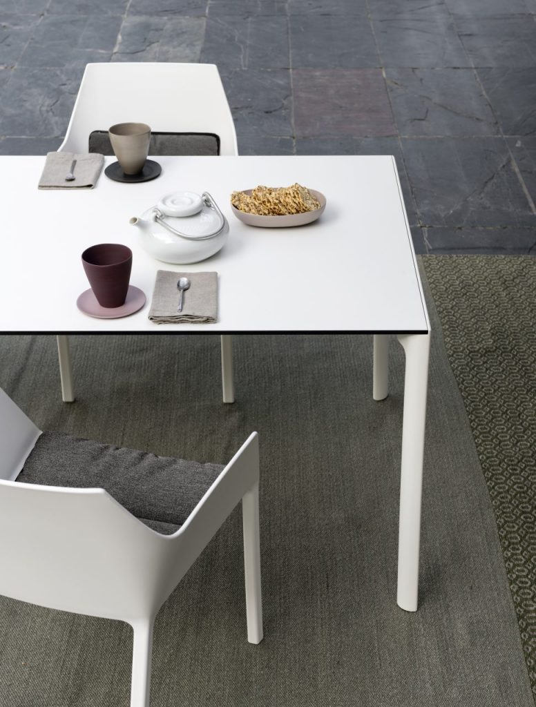 small square table made of white glass and aluminum legs in a white tone