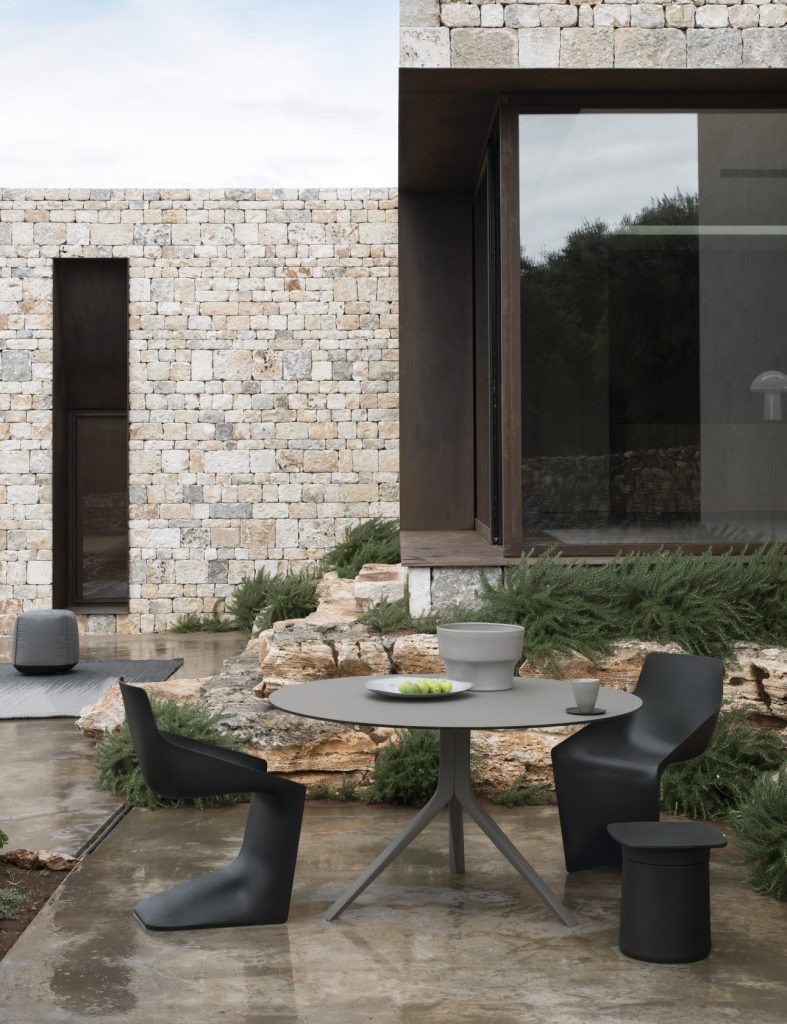 Extendable circle-shaped table made of wood and aluminum base in a gray tone