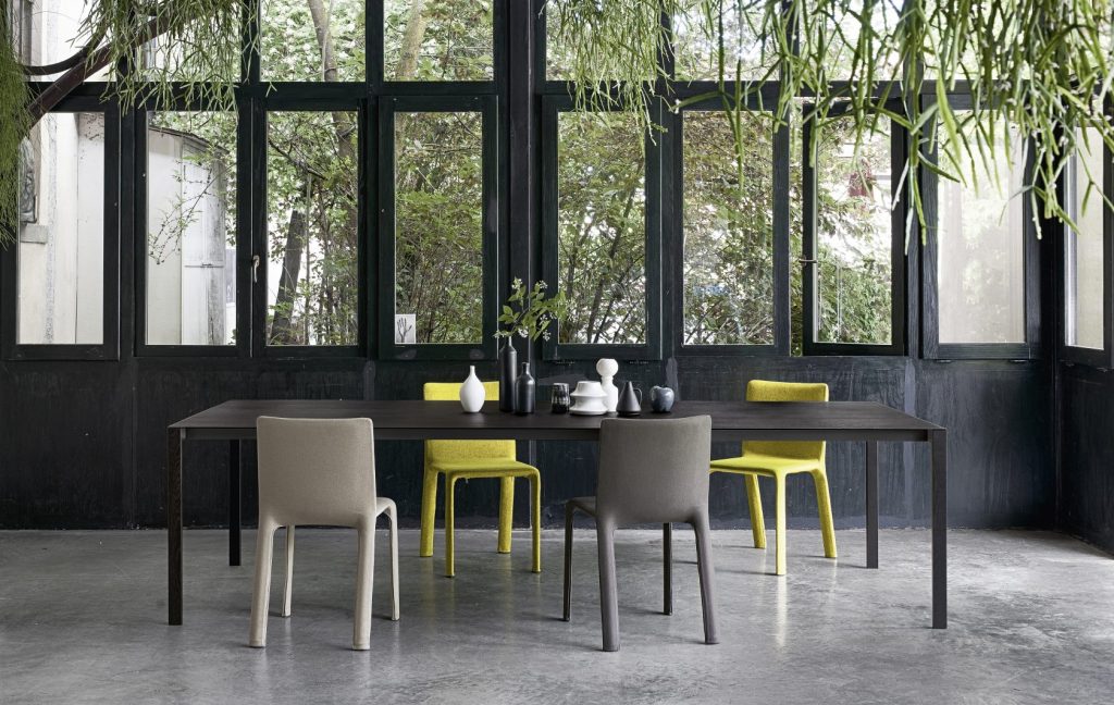 dining table made of metal and aluminum base in a black tone with chairs around it