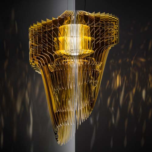 Lamp made up of fifty layers of various shell-shaped Cristalflex® in a shiny gold tone on a black background