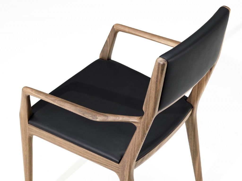 chair made of walnut wood base in a brown tone and upholstered in alamo fabric in a black tone