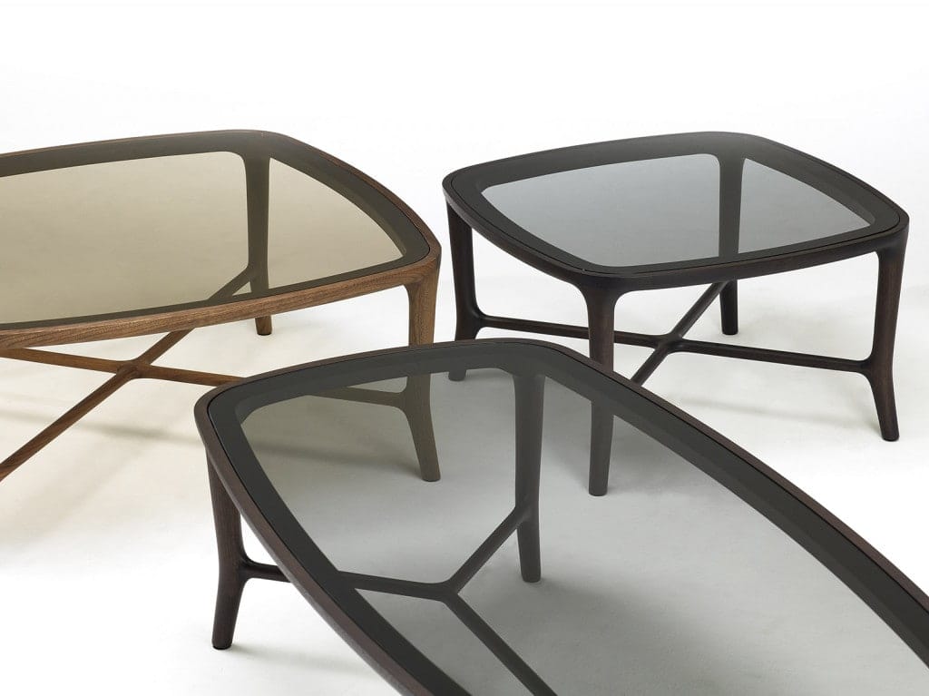 three low coffee tables made of walnut wood and glass in bronze and black tones on a white background