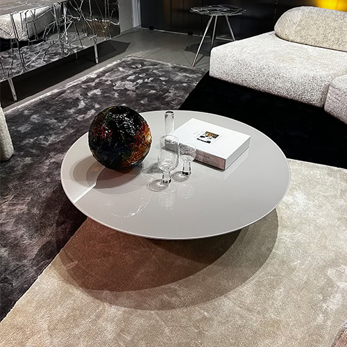 A stylish lounge area featuring the Ace Pond 120 Coffee Table, boasting a smooth circular surface, modern decor, and a cozy yet elegant vibe