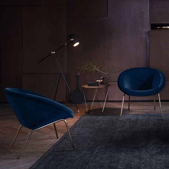 two chairs made with brass legs and covered in velvet fabric in a shade of blue.