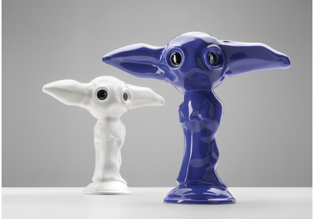 two small ceramic figurines made in the shape of an elf in shades of purple and white