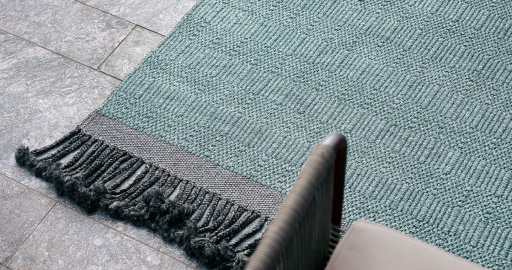 hand-woven rug in a green color tone with pattern design