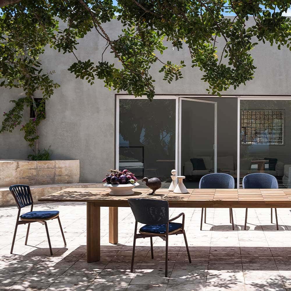 long dining table made of a light brown wooden base with a design in the form of squares or blocks