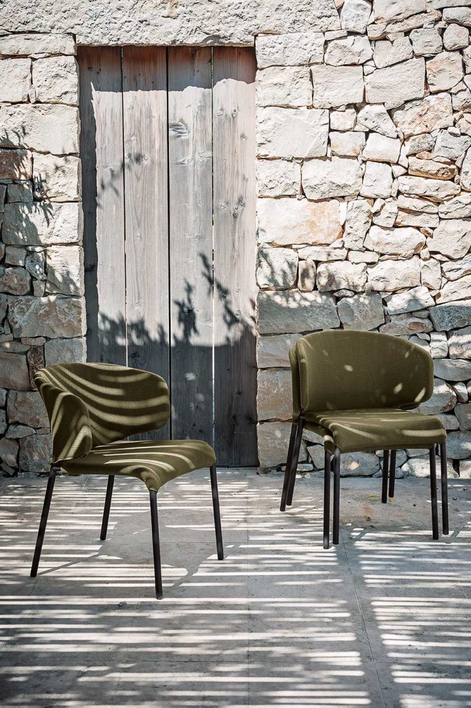 two chairs made with aluminum legs in a black tone and upholstered in military green fabric