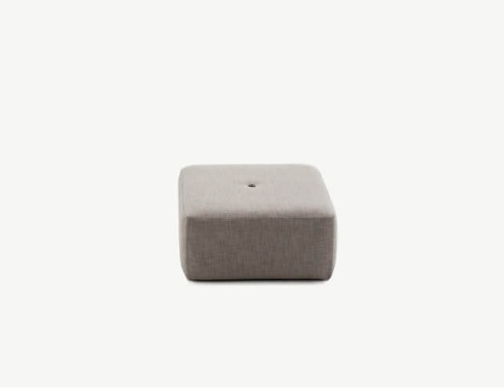 A low-profile square outdoor pouf in light taupe fabric, featuring a wide seat and a centered tufted detail.