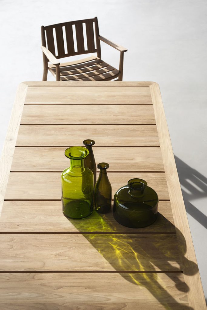 Close up top view of Levante Thirty Table with some bottles on top with a chair in the background