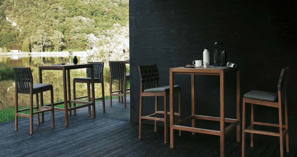 Few Plaza Sixty Seven Bar Table on a dark wooden floor with a dark wall and a stool at each table