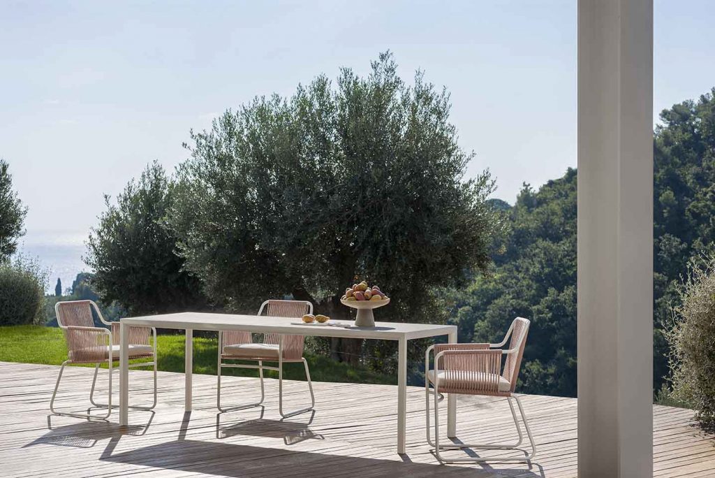 Plen Air Three Table with three chairs surrounding the table on a patio